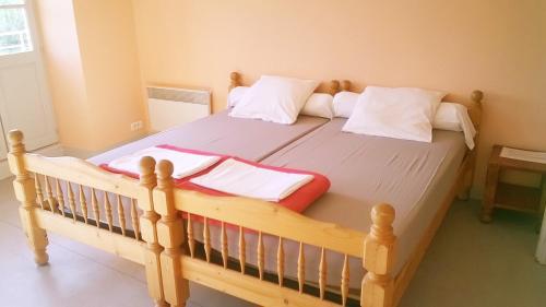 a bedroom with a wooden bed with white pillows at Domaine de Surgy in Surgy