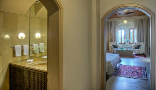 La salle de bains est pourvue d'un lavabo et d'un lit dans la chambre. dans l'établissement Mir Amin Palace, à Beiteddine