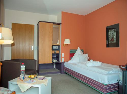 Habitación de hotel con cama y mesa en Parkhotel Hitzacker en Hitzacker