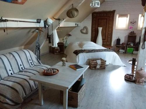 una camera con letto, tavolo e divano di Le grivé a Chèvremont