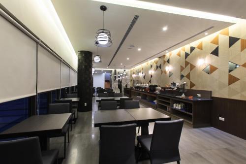 un restaurant avec des tables, des chaises et un comptoir dans l'établissement Chen He Spa Motel, à Lukang
