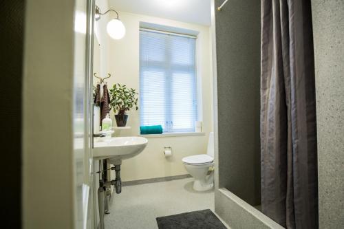 a bathroom with a sink and a toilet and a window at Bed & Breakfast Holstebro in Holstebro