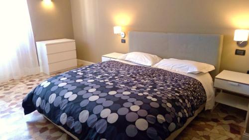 a bedroom with a bed with a blue and white comforter at Novegro Linate 101 in Linate