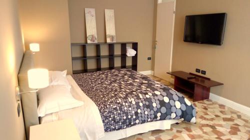 a bedroom with a bed and a flat screen tv at Novegro Linate 101 in Linate