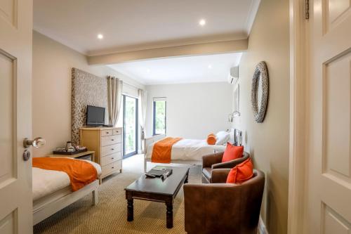 a hotel room with a bed and a desk at Orange Inn Knysna in Knysna