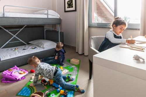two children playing in a bedroom with a bunk bed at Living Hotel Milano in Cornaredo