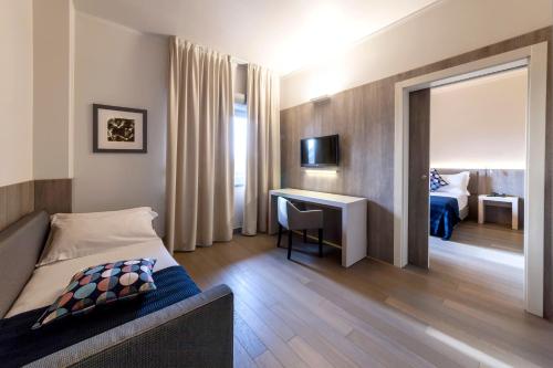 a hotel room with a bed and a desk and a bedroom at Living Hotel Milano in Cornaredo