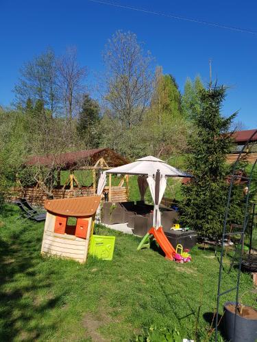 a backyard with a dog house and an umbrella at Pension Bran Ioana& SPA in Bran