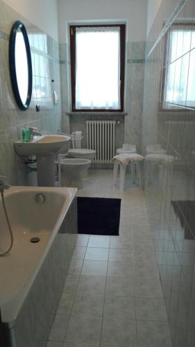a bathroom with two toilets and a tub and a sink at Appartamenti sapori di campagna in Pescantina