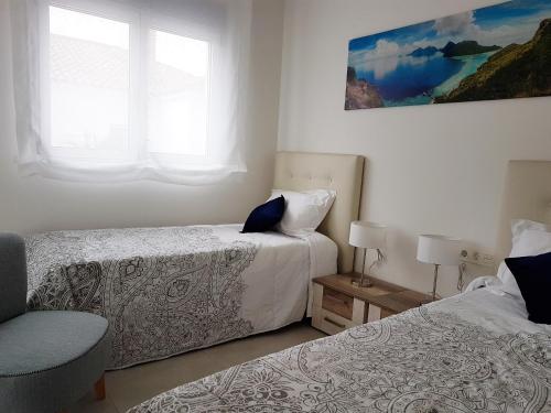 ein Schlafzimmer mit zwei Betten und einem Fenster in der Unterkunft Apartments Mirador de Villamartin LD001 in Los Dolses