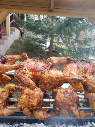 a group of chickens cooking on a grill at Pension Bran Ioana& SPA in Bran
