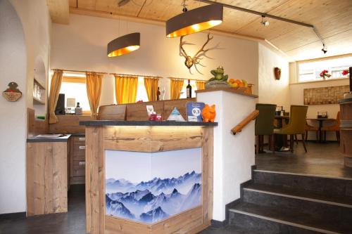 a kitchen with a counter with a painting of mountains at Pension Patricia - Summercard included from may 15th in Kaprun