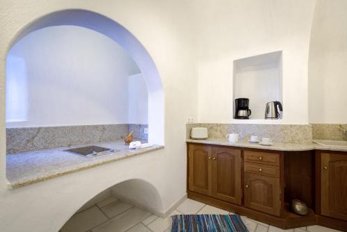 a bathroom with a sink and a bath tub at Chelidonia Traditional Villas in Oia