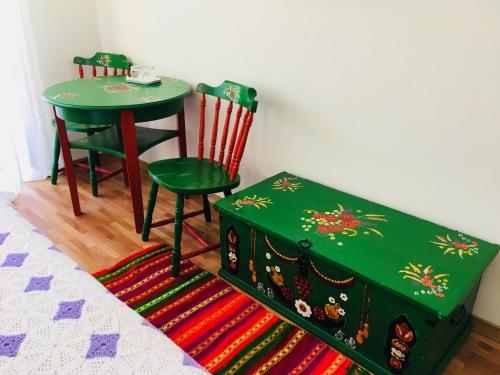 uma mesa verde e duas cadeiras e uma mesa e banco em Pensiunea Ambiance em Piatra Neamţ