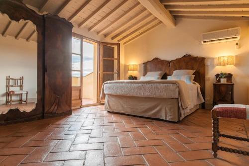 a bedroom with a large bed and a large window at Villa Aia Vecchia in Bibbona