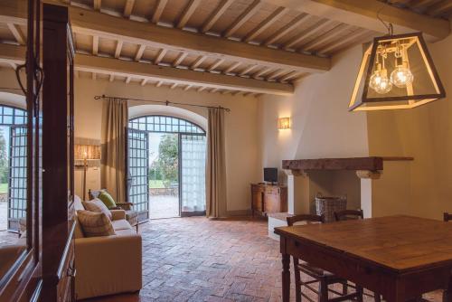 a living room with a table and a dining room at Villa Aia Vecchia in Bibbona
