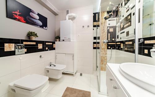 カルパチにあるApartamenty EverySky - Komuny Paryskiejの白いバスルーム(トイレ、シンク付)
