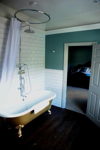 a bath tub in a room with a bedroom at The Tunbridge Wells Hotel in Royal Tunbridge Wells