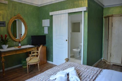 a bedroom with a bed and a desk and a mirror at Le Stanze del Console in Gravina in Puglia