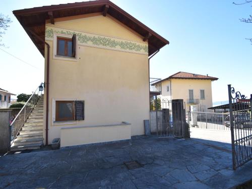 uma pequena casa com um alpendre e uma cerca em Belvilla by OYO Cannero Casa Iva em Cannero Riviera