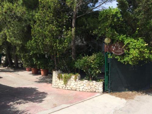 a green gate with plants on it next to trees at Villa Irene in Vieste