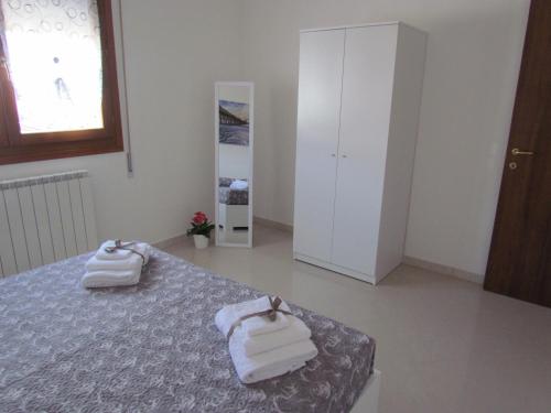 a bedroom with a bed with towels on it at Siviero Apartments in Scardovari