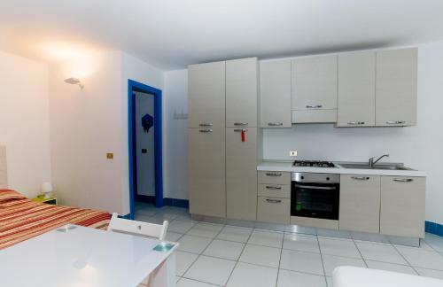 a kitchen with white cabinets and a stove top oven at Lignano Luxury Villa***** in Lignano Sabbiadoro