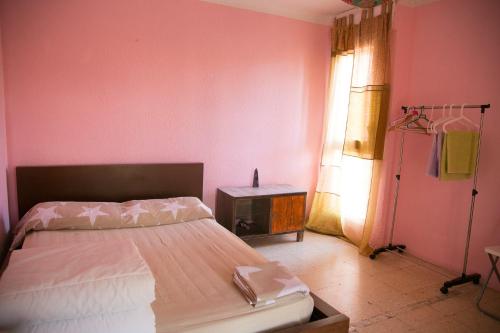 een slaapkamer met een bed, een tafel en een raam bij Habitaciones cerca del mar in Reus