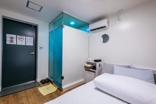 a bedroom with a bed and a blue door at K Stay Guesthouse Myeongdong first in Seoul