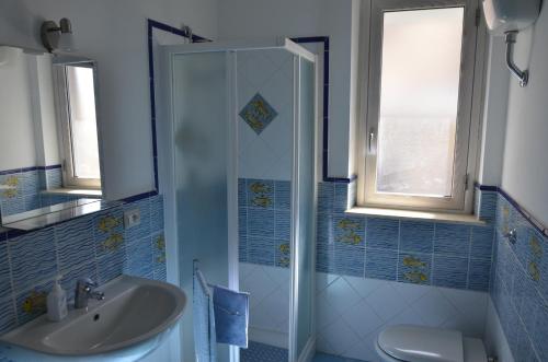uma casa de banho com um lavatório e um chuveiro em residence scala dei turchi em Realmonte