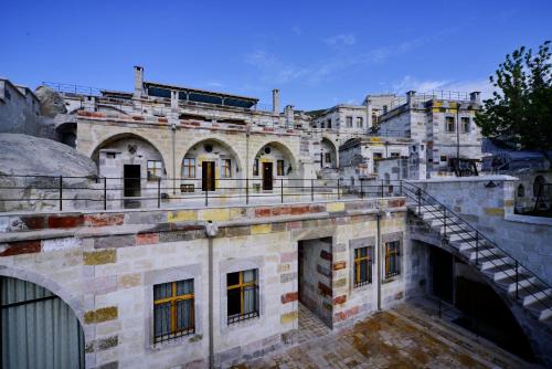 an old stone building with a staircase in front at Seki Cave Suites in Goreme