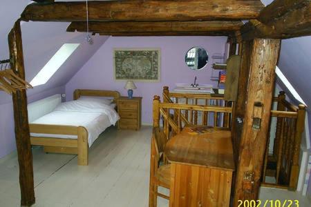 ein Schlafzimmer mit einem Bett und einem Schreibtisch in einem Zimmer in der Unterkunft Altes Tagelöhnerhaus von 1510 mit Garten und Parkplatz in Goslar