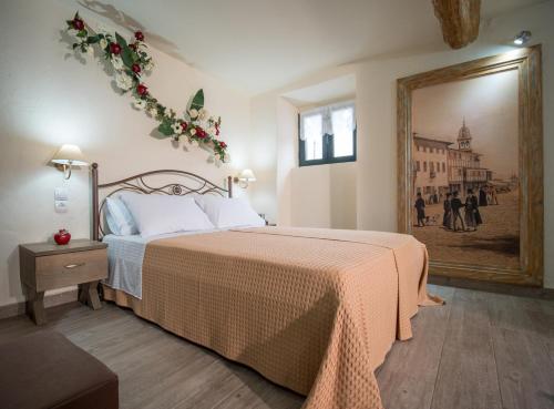a bedroom with a bed and a painting on the wall at Vorto House in Agios Leon