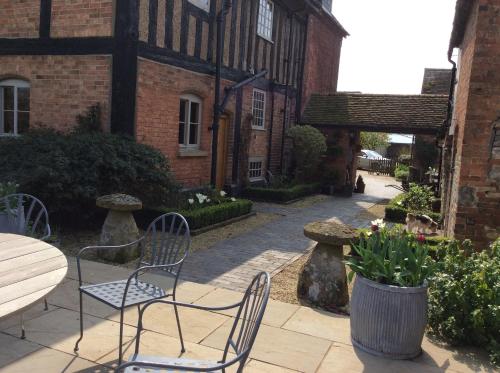 a patio with chairs and a table in front of a building at White Hall Farm in Leamington Spa