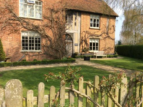 a brick house with a wooden fence in front of it at White Hall Farm in Leamington Spa