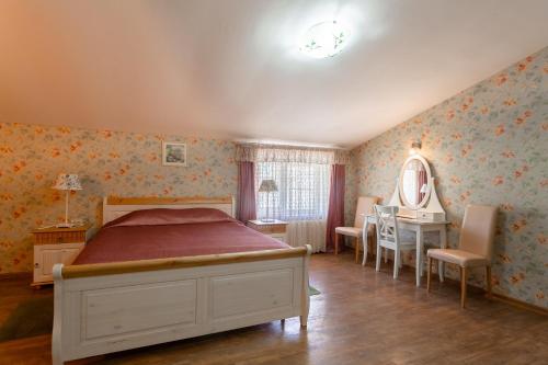 
a bedroom with a bed, chair, and a window at Russkoe Podvorie in Rostov
