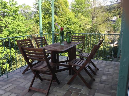 a wooden table and four chairs on a patio at Ferienwohnung Villa Josephine in Badenweiler