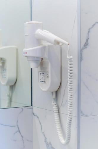 a white phone on a wall in a bathroom at Room 25 Belgrade in Belgrade