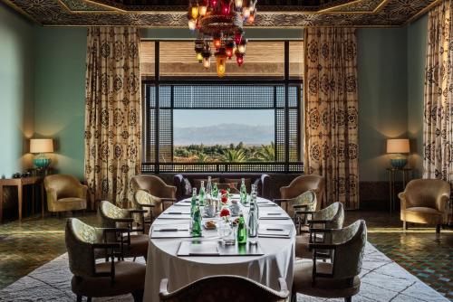 a dining room with a table and chairs and a chandelier at Fairmont Royal Palm Marrakech in Marrakech
