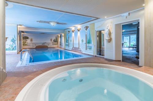 uma grande banheira num quarto com piscina em Bio & BikeHotel Steineggerhof em Collepietra