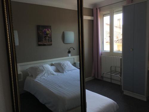 a mirror reflection of a bed in a bedroom at Le Relais de Gascogne in Auch