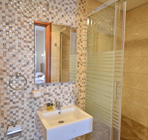 a bathroom with a sink and a shower at Pelineon Rooms in Chios
