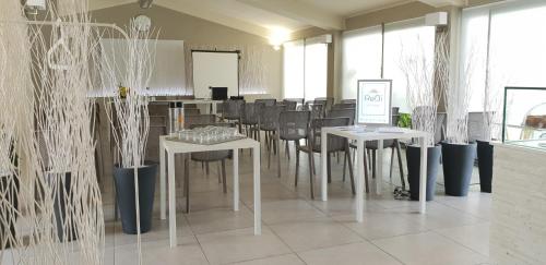 a dining room with tables and chairs and windows at ReBi Village in Imperia
