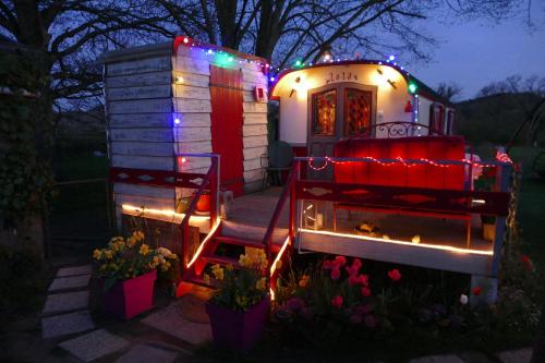 a tiny house with christmas lights on it at La Roulotte De Lola - Chambre d'hôtes in La Celle