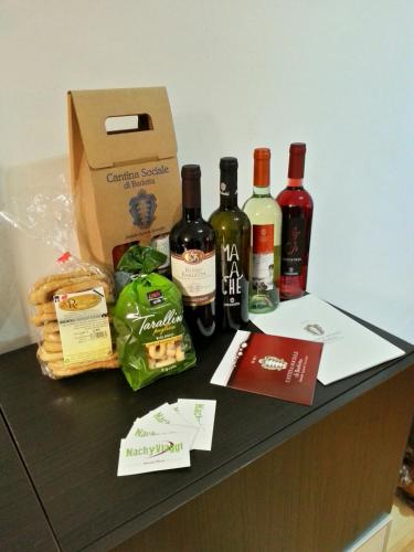 a group of wine bottles and a box on a counter at Le Statuine Dimore Diffuse in Barletta