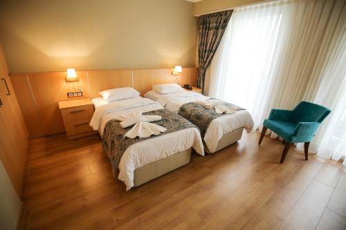 una camera d'albergo con due letti e una sedia blu di Artika Hotel a Istanbul