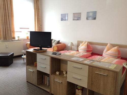 a bedroom with a bed and a desk with a television on it at Ferienwohnung Lilly in Wittenberge