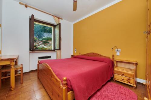 1 dormitorio con cama, escritorio y ventana en Residence Mariù, en Malcesine