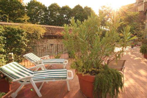 two lawn chairs sitting on a patio with plants at Studios Garden Terrace Oltrarno in Florence