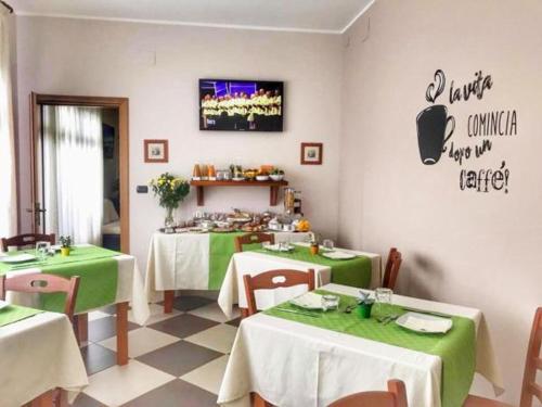 a restaurant with two tables with green tablecloths at Sweet Home B&B in San Ferdinando